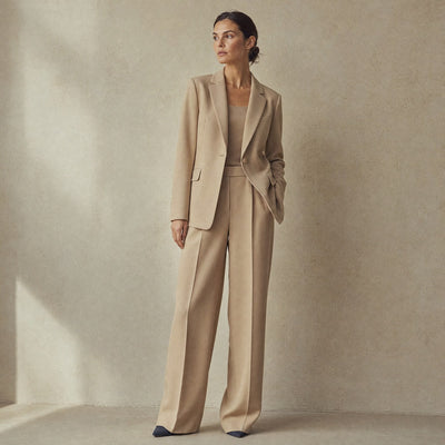 Kvinde i beige blazer og matchende vide bukser